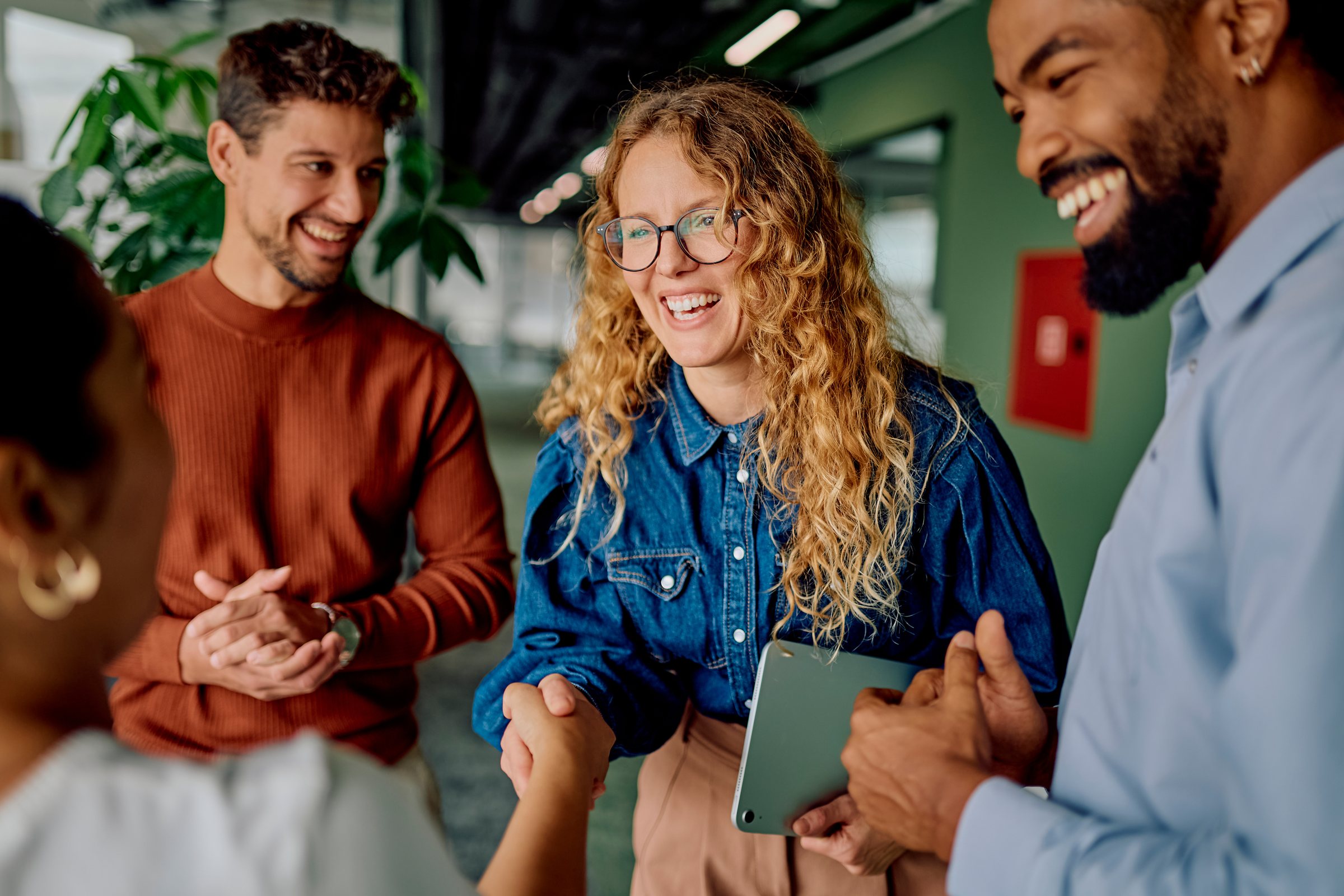 Colleagues shaking hands and smiling after a meeting